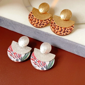 Detail of round wood earrings with gold metal accents and vintage leopard floral patterns