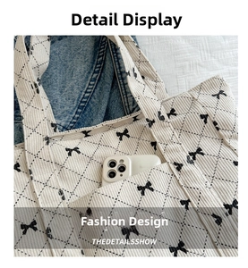 Detail of corduroy tote bag with bow prints and quilted texture showing a phone pocket