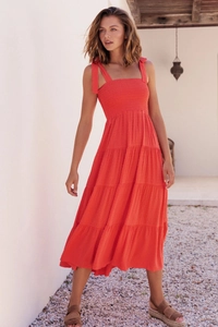 Detail of coral red midi dress showing tiered skirt and swiss dot textured fabric texture