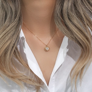 Close-up of heart-shaped pendant with white mother of pearl inlay in 18K gold plating