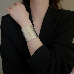 Detail of silver textured irregular hammered metal cuff bracelet worn by a model