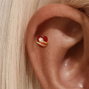 Detailed view of an s925 silver heart-shaped red gemstone stud wrapped in a golden snake