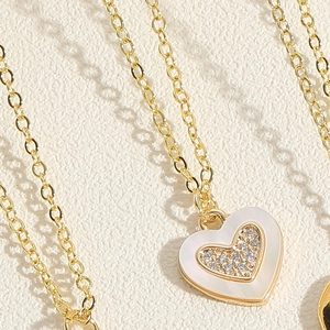 Macro view of heart pendant necklace with white shell inlay and paved cubic zirconia