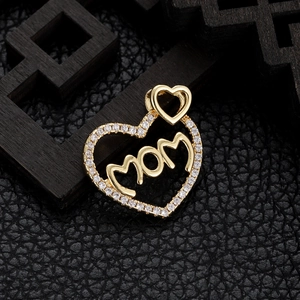 Detailed close-up of gold-plated heart pendant with MOM script and sparkling crystals