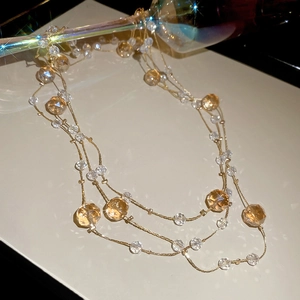 Detail of multi-layered champagne crystal beaded necklace with golden chain link