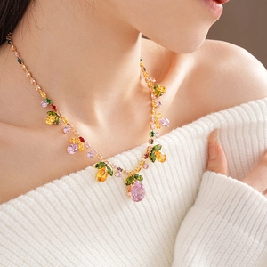 Luxurious gold necklace with colorful zircon gemstones worn on model with elegant white top