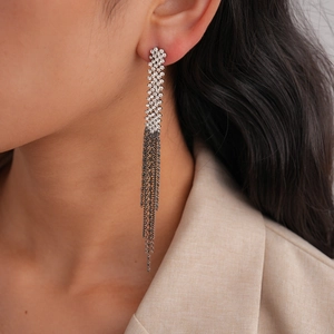 Close-up of sparkling rhinestone tassel earrings with silver finish on a model