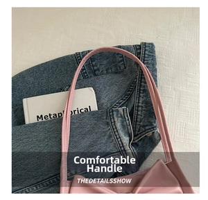 Detail of soft light pink PU leather tote bag handle with refined stitching and books
