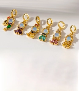 Macro shot of gold-plated mermaid tail pendants with colorful opals and sparkling zircons