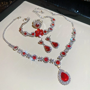 Detail of red teardrop gems and floral crystals on luxury necklace and earring jewelry set
