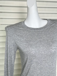 Detail of grey wool tencel long sleeve top neck and shoulder on a mannequin
