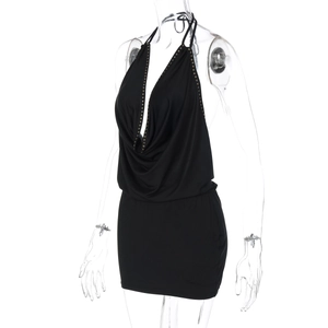Details des schwarzen Halter-Minikleids mit Wasserfall-Ausschnitt und Goldnieten