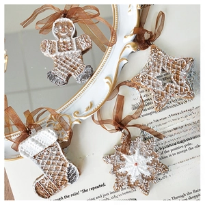 Detailed view of gingerbread man and snowflake resin ornaments on a vintage gold mirror