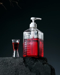 Detail view of a 1100ml glass syrup bottle with clear scale and white plastic pump head