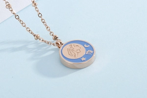 Macro shot of rose gold Virgo coin pendant with blue enamel, moon and stars details