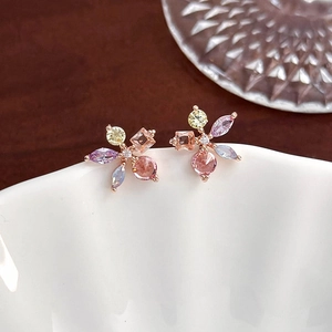 Detail shot of colorful zircon flower earrings on white ceramic in a lifestyle setting