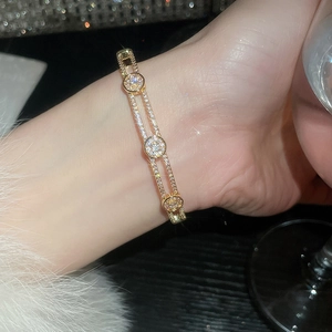 Vue détaillée d'un bracelet géométrique plaqué or avec trois cercles ornés de cristaux