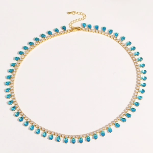 Detail of gold-plated choker with sparkling blue teardrop and round white zircons