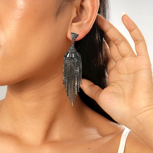 Detail of dark gothic fan-shaped earrings with long tassel crystal fringe on a model