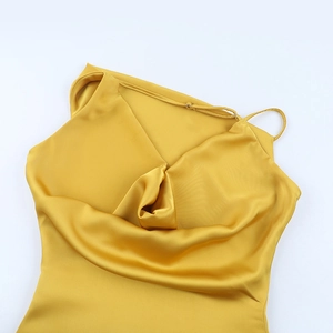 Détail d'une robe de soirée en satin doré montrant l'élégant décolleté bénitier