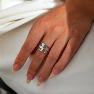 Close-up of a silver multi-layered adjustable ring featuring a white five-petal flower