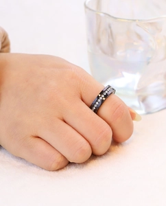 Detailed view of 6mm black stainless steel ring with zircon stones on a model's hand