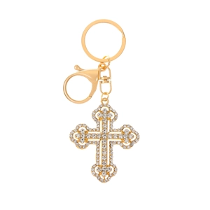 Close-up of golden metal cross keychain with sparkling rhinestones and spring clasp