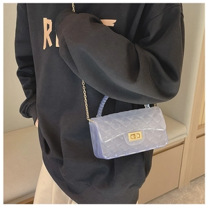 Detail of blue transparent jelly bag featuring quilted pattern and pearl beaded handle
