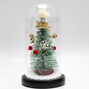 Macro detail of Christmas tree glass dome with LED lights, mini ornaments and fake snow