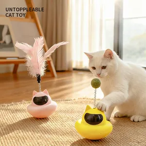Interactive tumbler cat toy with pink feathers and suction cup on wooden floor