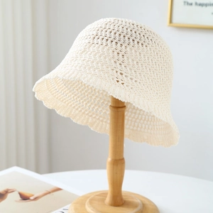 Detail of a cream hollow knit bucket hat featuring a breathable sun protection texture