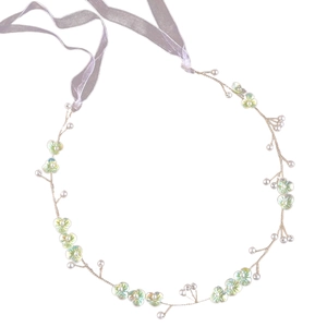 Detail of bridal headband with green resin flowers, white pearls and purple ribbons