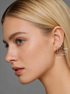 Detailed view of four different sizes 10mm to 15mm sterling silver hoop earrings on ear