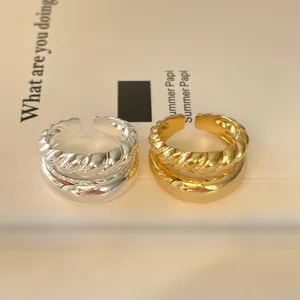 Detailed close-up of double-layer twist gold and silver rings on decorative card