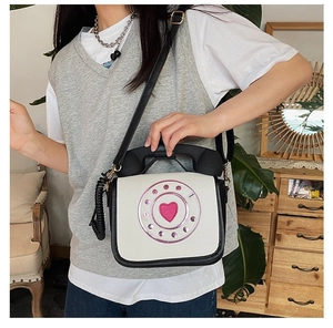 Side view of a woman wearing a novelty white telephone shaped crossbody handbag