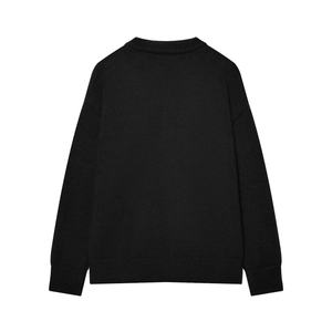 Detailed back view of a black knit sweater featuring ribbed hem and cuff textures