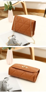 Detail of caramel quilted crossbody bag with golden twist lock and chain strap