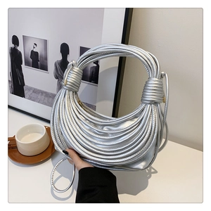 Detail of silver knotted shoulder bag with metallic finish and twisted strap design