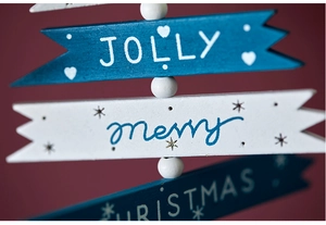 Close-up of wooden Christmas arrow signs with Jolly Merry Christmas lettering and beads