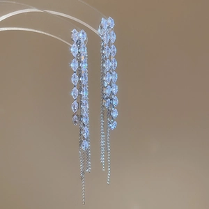 Detailed view of silver tassel earrings with sparkling rhinestones and long chain fringe