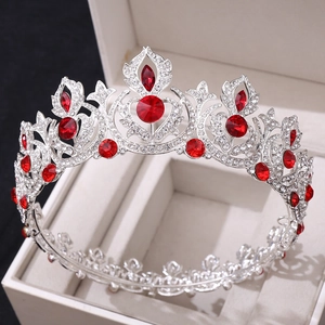 Close-up of a silver tiara with red crystals and clear rhinestones in a white gift box