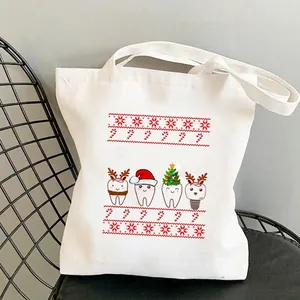 Canvas tote bag with Christmas tooth print hanging on a chair in a minimalist room