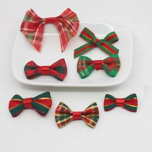Set of 7 festive red and green plaid Christmas bow cake toppers on a white plate