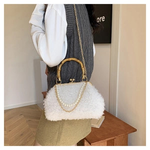 Detail of white lambwool shell bag with bamboo handle and elegant pearl chain accessory