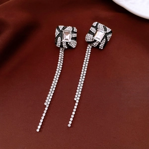 Close-up of square stud earrings with crystal center and sparkling tassel chains