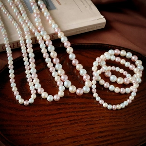 Détail d'un ensemble de collier et bracelet en perles vintage sur un plateau en bois