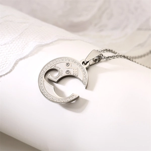 Detailed close-up of crescent moon puzzle pendant with love you engraving and small diamonds