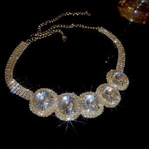 Detail of luxury gold necklace featuring large oval crystals and pavé diamond setting