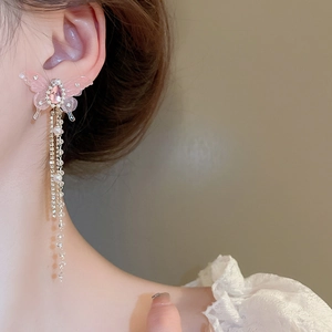 Detail of pink crystal butterfly earrings with long rhinestone and pearl tassels