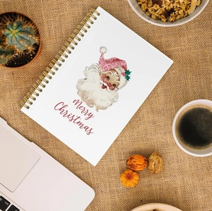 Flat lay of vintage Santa spiral notebook on burlap background with desk accessories